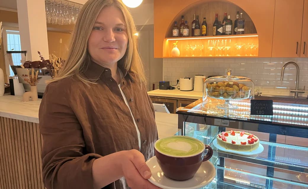 Mitarbeiterin von Nashe Café reicht ein Getränk über die Theke